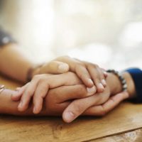 Closeup shot of two unrecognizable people holding hands in comfort